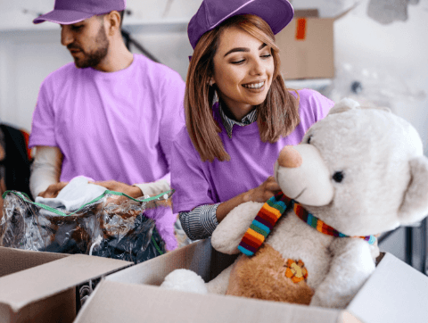 woman looks at stuffed animal in a cardboard box